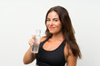 © luismolinero - Young woman over isolated white background with a bottle of water