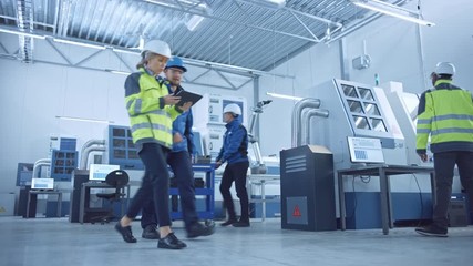 Fototapete - Indusry 4.0 Factory: Team of Engineers, Technicians, Professionals and Workers, Working on Assembly and Production Line, Optimizing CNC Machinery, Programming Machines, Talking and Planning Projects 