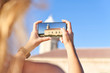 © Westend61 - Young woman taking pictures of Punta Nati lighthouse, Menorca, Spain