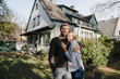 © Westend61 - Portrait of smiling couple standing in front of their home