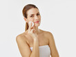 © Westend61 - Portrait of smiling woman cleaning face with cotton pad