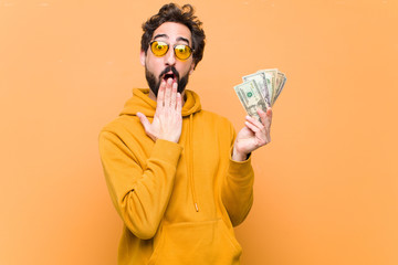 Poster - young crazy cool man with dollar banknotes against orange wall