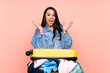 © luismolinero - Traveler Colombian girl with a suitcase full of clothes over isolated pink background unhappy and frustrated with something
