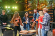 © gorynvd - Group of friends are dancing at outdoors barbecue party in the house courtyard.