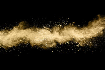 Wall Mural - Golden powder explosion on black background. Freeze motion.