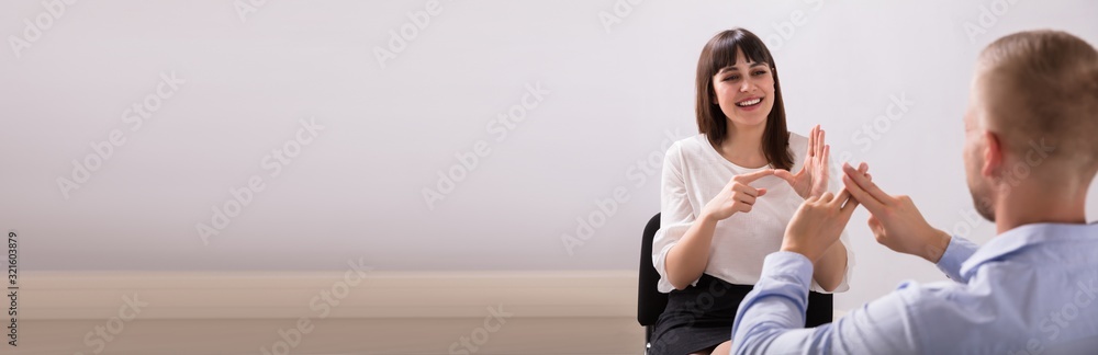 Young Woman And Man Talking With Sign Language - obrazy, fototapety, plakaty 