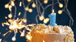 © Stanislav - Birthday cake with 1 number candles and burning sparkler on blue backgraund. Close-up
