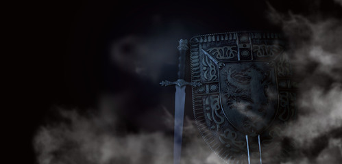 photo of shield knight armor and sword in the fog smoke over dark background. Medieval period concept