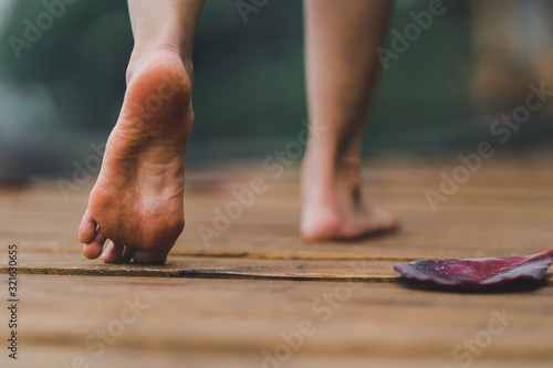 Cuadros en Lienzo barefoot girl with walking on the bridge wood with blur background outdoor natur