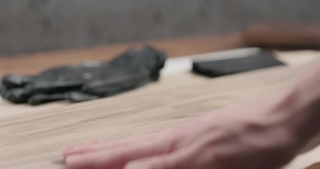 Sticker - Slow motion man hand cleans black walnut board before applying finish