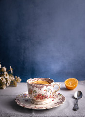 Vintage tea cup with floral design with rustic background