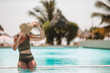 © travnikovstudio - Woman relaxing by the pool in a luxury hotel resort enjoying perfect beach holiday vacation
