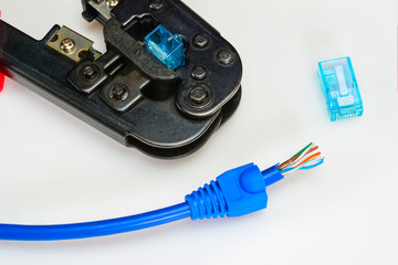 RJ45 connectors, blue boot for rj-45 plug, patchcord and crimping tool for home Internet connection. Home network concept, close-up.