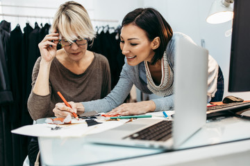 Two professional designers working in fashion studio. Creative people concept.