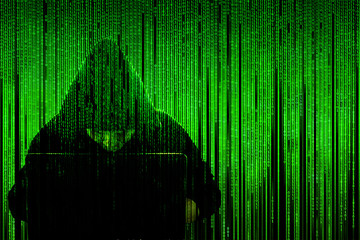 Wall Mural - Silhouette of a hacker in a hood with a laptop on a background of a matrix of binary computer code. Concept: computer security, hacker and computer virus, hacking database.