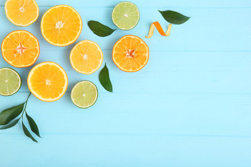 Different citrus and juicy slices on a colored background top view. Place to insert text.