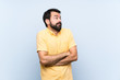 © luismolinero - Young man with beard over isolated blue background making doubts gesture while lifting the shoulders