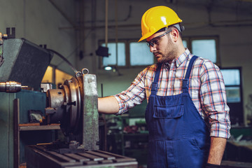 Sticker - Turner worker is working on a lathe machine in a factory.  