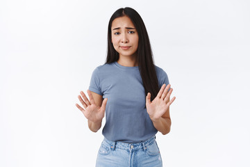 Skeptical, arrogant and unamused asian woman, raising arms in stop, refusal motion, smirk and frowning judgemental dislike offer, uninterested in product, standing white background