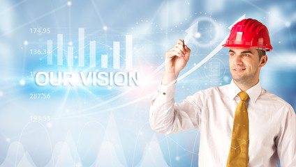 Young businessman with helmet drawing OUR VISION inscription, modern business technology concept