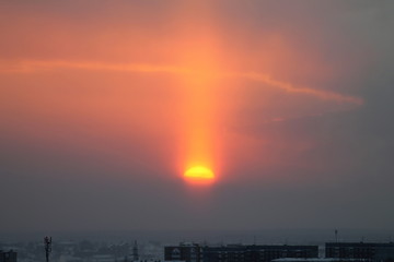 Wall Mural - sunrise or sunset a piece of red sun over the city