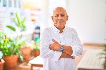 Wall Mural - senior handsome man smiling wih happy and confident. sitting with smile on face at terrace