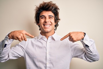 Young handsome businessman wearing elegant shirt standing over isolated white background looking confident with smile on face, pointing oneself with fingers proud and happy.