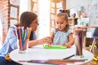 © Krakenimages.com - Caucasian girl kid playing and learning at playschool with female teacher. Mother and daughter at playroom around toys drawing on magnetic blackboard