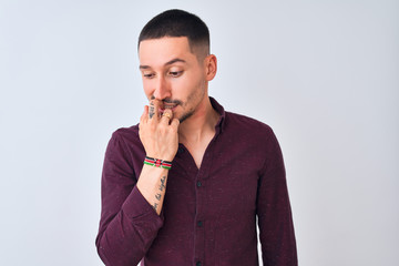 Wall Mural - Young handsome business man standing over isolated background looking stressed and nervous with hands on mouth biting nails. Anxiety problem.