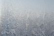 Frozen drops of condensed steam water drops on the transparent window glass. Clean background. Condensation of moisture at extreme temperatures. Water vapor condenses on cold window glass and freezes