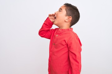 Sticker - Beautiful kid boy wearing elegant red shirt standing over isolated white background shouting and screaming loud to side with hand on mouth. Communication concept.