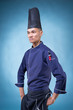 © HEMINXYLAN - A portrait of an Asian executive chef in his blue uniform, black apron and black hat on blue background