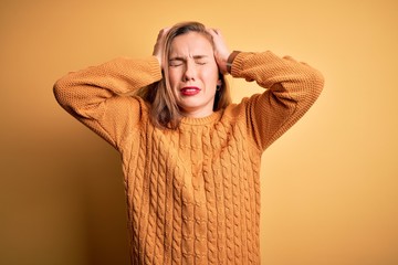 Sticker - Young beautiful blonde woman wearing casual sweater standing over yellow background suffering from headache desperate and stressed because pain and migraine. Hands on head.