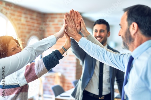 Group of business workers standing with hands together highing five at the offic Tableau sur Toile