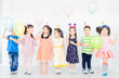 © jokekung - pretty asian children group standing and celebrate on gray background, they feeling happy in birthday party, they smile and play together, the holding Helium balloon, Christmas and new years party