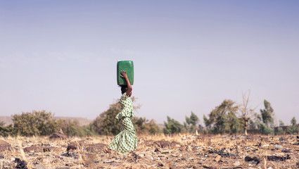 candid photo of african girl saving fresh water in an arid zone