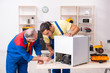 © Elnur - Two contractors repairing fridge at workshop