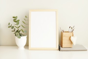 Minimalist interior empty frame mock up on white background, eucalyptus and wooden decoration.       