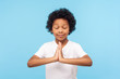 © khosrork - Portrait of nice little curly boy holding arms in prayer and meditating with closed eyes, smiling feeling calm relaxed with peaceful mind, yoga practice. indoor studio shot isolated on blue background