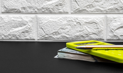 Wall Mural - Calculator with money and pen on the black table.