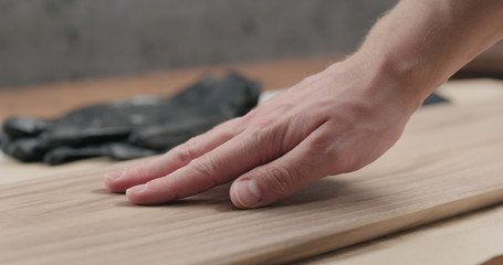 Canvas Print - man hand touches black walnut board