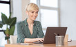 © Prostock-studio - Mature Lady Working On Laptop In Earphones Sitting In Office