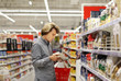 © lado2016 - Man shopping in supermarket, reading product information