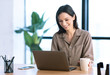 © Prostock-studio - Portrait of smiling woman working on laptop with tea