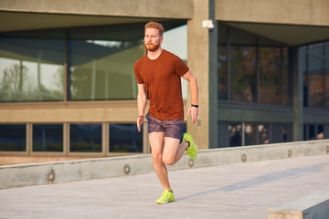 Young man exercising / running in urban park.