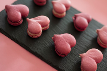 Many pink macaroons in the heart shape