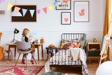Cute Little Girl Sitting At Desk In Her Stylish Vintage Bedroom With Workspace