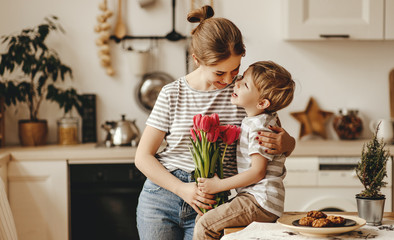 Wall Mural - happy mother's day! child son gives flowers for mother on holiday