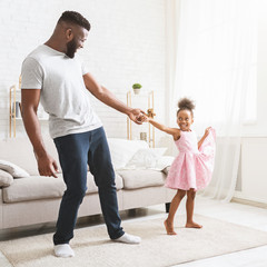 Artisctic baby girl dancing with her handsome father