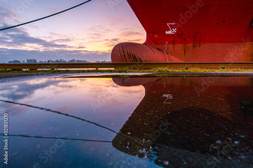 Fotomural Schiffsbug mit Spiegelung zum Sonnenuntergang